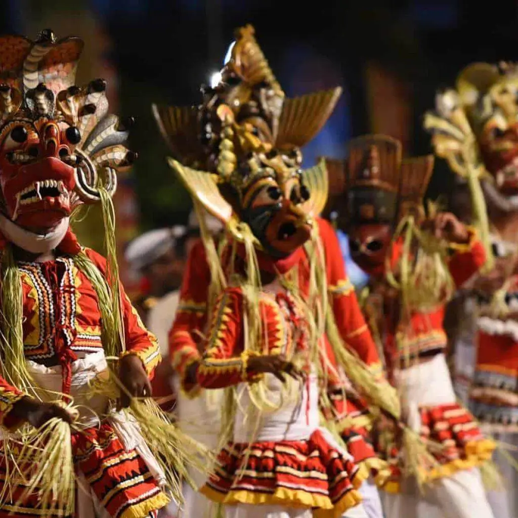Masked dancers in red and gold costumes at a perahera procession