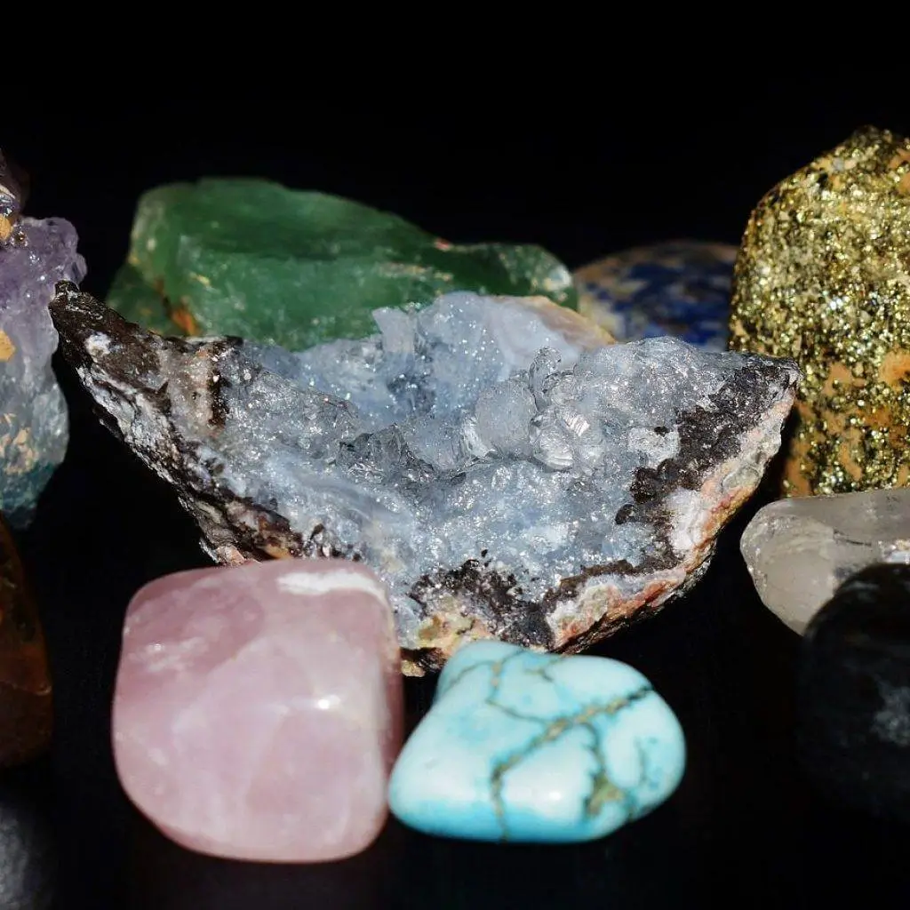 Polished gemstones of many colours on a black background