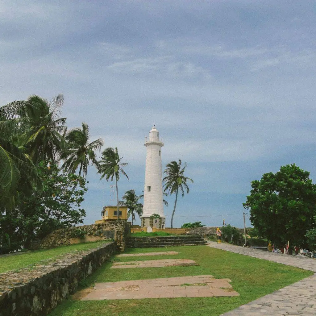 The Galle Fort lighthouse among palm trees