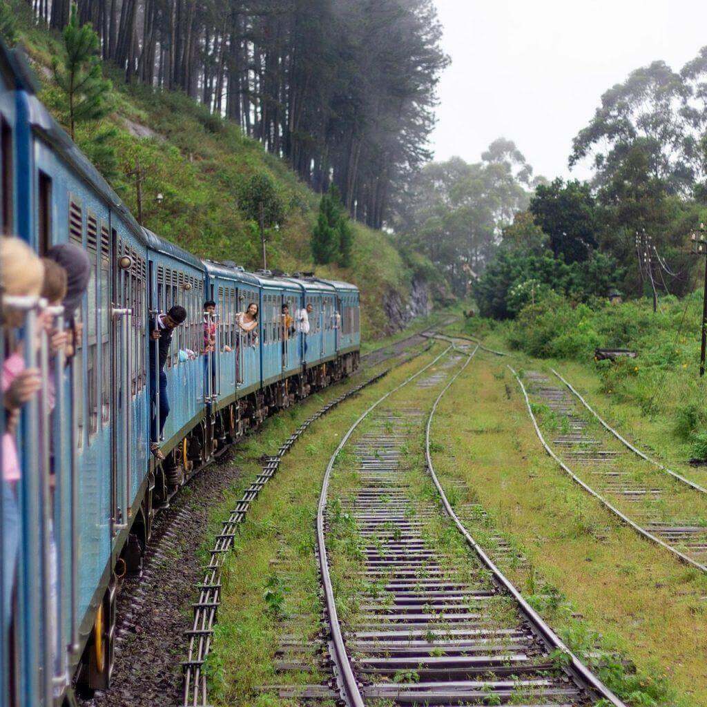 A blue train running through green hill country