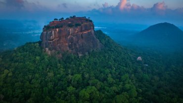 The Sigiriya rock fortress above the forest at dusk, seen from the air