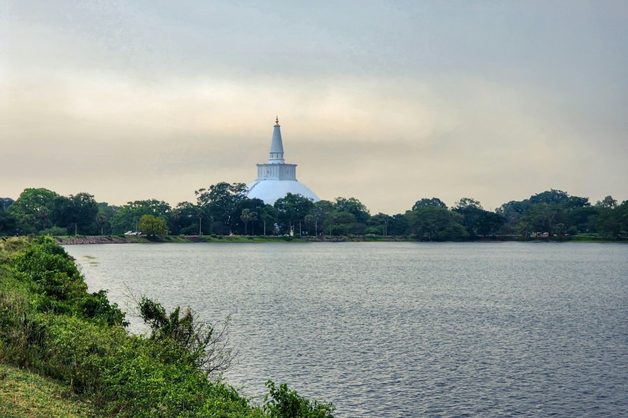A white stupa seen across a reservoir in Anuradhapura