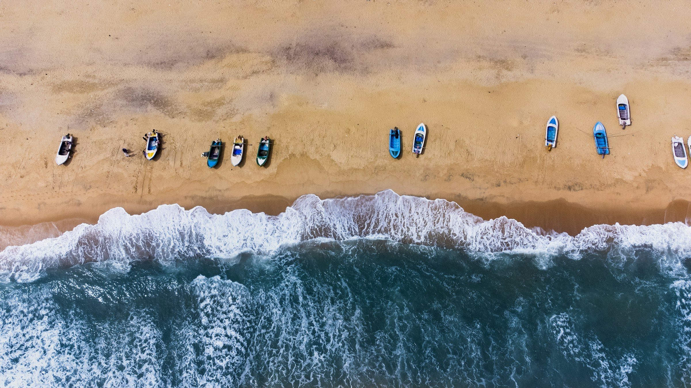 Surfboards and waves on the beach at Arugam Bay, seen from the air