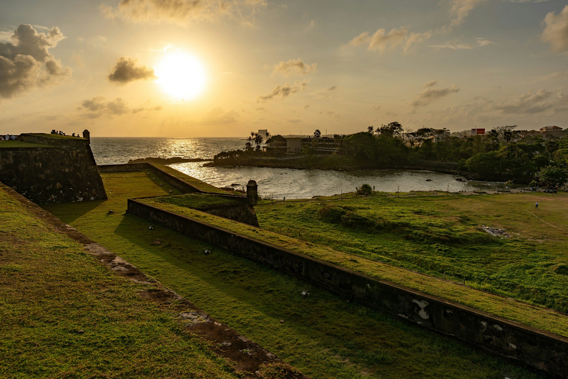The stone ramparts of Galle Fort above the ocean in the low evening sun