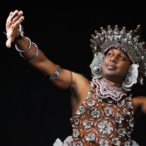 A Kandyan ves dancer in his silver headdress and beaded costume