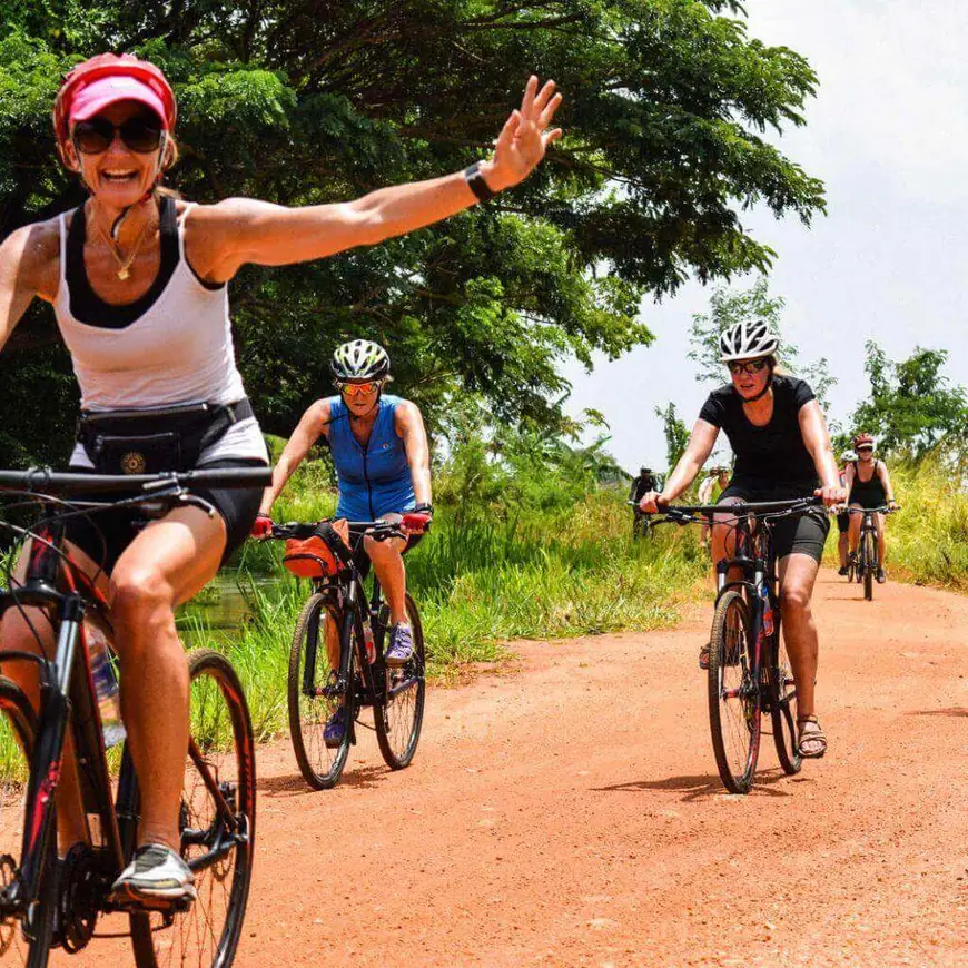 Cyclists on a red dirt road near Dambulla